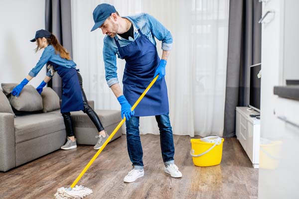 Housekeeping staff cleaning a school hallway